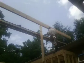 Carpenter setting a ridge beam over a new addition frame — Ice Dam Removal by Roofing Brothers in Columbia Falls