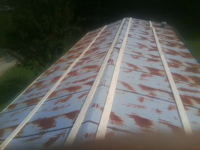 Rusted metal roof panels with new wood purlins before replacement — Storm Damage Roof Repair in Columbia Falls by Roofing Brothers